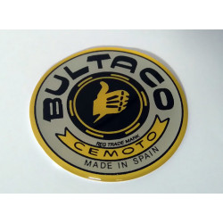 Anagrama deposito Bultaco color gris, borde amarillo.